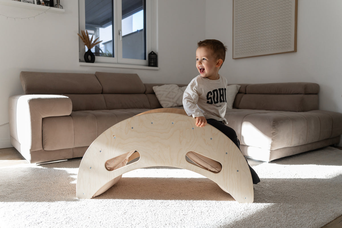 Kind auf einem Kletterbogen aus Holz im Wohnzimmer
