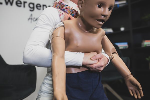 Heimlich-Manöver beim Kind, demonstriert an einer Puppe